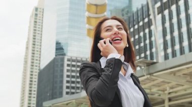 Şehirdeki telefonu kullanan Asyalı genç ve zeki iş kadını.