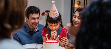 Çok ırklı büyük bir aile, küçük kız çocukları için doğum günü partisi veriyor. Çok hoş bir çeşitlilik anı. İnsanlar küçük kız çocuğuna doğum günü şarkısı söylüyor. Sonra da yemek masasında pastaya mum üflüyor.