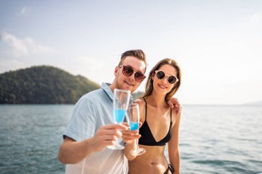 Kafkasyalı bir çiftin portresi şampanya içiyor, yatta parti veriyor. Çekici bir erkek ve kadın birlikte takılıyor, yıl dönümü balayı gezisini kutlarken katamaran teknesi yaz günbatımında yelken açıyor..