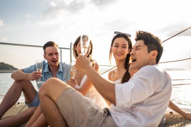Çeşitli arkadaşlar yatta parti yaparken şampanya içerler. Çekici genç erkek ve kadınlar birlikte takılıyor, tatil tatilini kutlarken katamaran teknesi yaz günbatımında yelken açıyor..