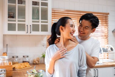 Asyalı romantik adam mutfakta kolyesiyle sürpriz sevgili yapıyor. Çekici, romantik, yeni evli çift erkek ve kadın birlikte vakit geçiriyorlar. Yıldönümünü ve sevgililer gününü evde kutluyorlar..