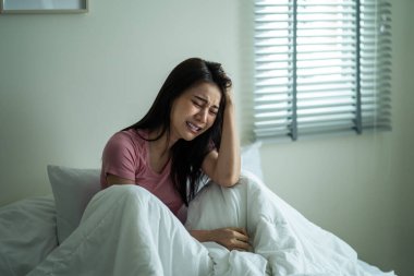 Asyalı güzel bir kadın yatak odasında tek başına otururken kızgın hisseder. Çekici, üzgün, üzgün bir kız evdeki sorunlardan rahatsız, üzgün ve üzgün. Sağlık hizmetleri Tıbbi Konsepti.