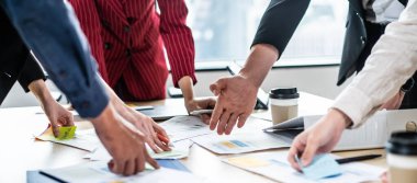 Ofiste toplanan iş adamı ve kadın grupları yakın mesafede. Çalışan beyin fırtınası ve takım olarak çalışmak, kağıt üzerinde projeleri planlamak ve tartışmak. Modern iş arkadaşları ya da iş arkadaşları