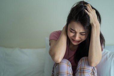 Asyalı genç üzgün kadın evde tek başına oturuyor. Çekici mutsuz kadın çok üzgün, yalnız ve hayal kırıklığına uğramış para borçlarını, bütçe kayıplarını, iflasları düşün.