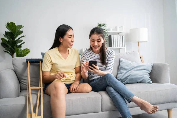 Güzel bir arkadaşla cep telefonu kullanan Asyalı bir ampütasyon. Çekici, bacaksız kız ve oda arkadaşı kanepede oturup boş vakitlerini birlikte online alışveriş yaparak geçiriyorlar.