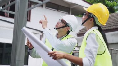 Asyalı işçiler, covid salgın krizi nedeniyle mimari alanında koruyucu yüz maskesi takıyorlar..