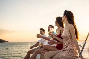 Çeşitli arkadaşlar yatta parti yaparken şampanya içerler. Çekici genç erkek ve kadınlar birlikte takılıyor, tatil tatilini kutlarken katamaran teknesi yaz günbatımında yelken açıyor..