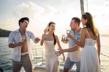Çeşitli arkadaşlar yatta parti yaparken şampanya içerler. Çekici genç erkek ve kadınlar birlikte takılıyor, tatil tatilini kutlarken katamaran teknesi yaz günbatımında yelken açıyor..