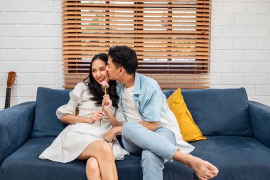 Asyalı genç adam sürpriz yaptı ve gül çiçeğini güzel kız arkadaşına verdi. Çekici, romantik, yeni evli çift erkek ve kadın yıl dönümünü ve Sevgililer Günü 'nü kutlamak için birlikte evde vakit geçirirler..