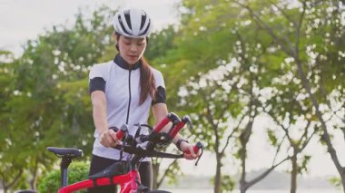 Asyalı genç ve güzel bir kadın akşam vakti bisiklet sürerek sağlığına kavuşuyor..