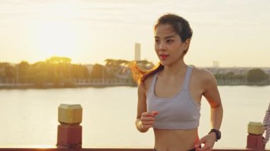Asyalı genç ve güzel bir kadın akşam vakti sağlık için koşuyor. Sokakta, parkta..