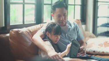 Asyalı baba ve kızı dijital tabletle oynuyorlar