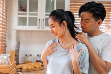 Asyalı romantik adam mutfakta kolyesiyle sürpriz sevgili yapıyor. Çekici, romantik, yeni evli çift erkek ve kadın birlikte vakit geçiriyorlar. Yıldönümünü ve sevgililer gününü evde kutluyorlar..