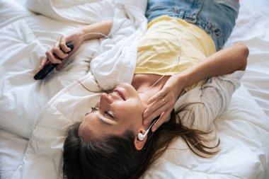 Kafkasyalı genç bir kadın evde yatarken müzik dinler. Çekici genç kız kulaklığını taktı ve evde boş zaman geçirmekten ve hafta sonu aktivitelerinin keyfini çıkarmaktan mutlu oldu..