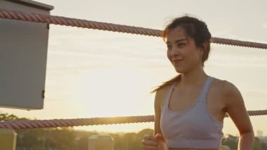 Asyalı genç ve güzel bir kadın akşam vakti sağlık için koşuyor. Sokakta, parkta..