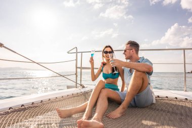 Kafkasyalı genç bir çift yatta parti yaparken şampanya içiyor. Çekici bir erkek ve kadın birlikte takılıyor, yıl dönümü balayı gezisini kutlarken katamaran teknesi yaz günbatımında yelken açıyor..