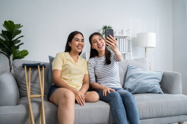 Güzel bir arkadaşla cep telefonu kullanan Asyalı bir ampütasyon. Çekici, bacaksız kız ve oda arkadaşı kanepede oturup boş vakitlerini birlikte online alışveriş yaparak geçiriyorlar.