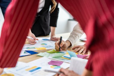 Ofiste çalışan genç iş adamları ve iş kadınlarına yakın durun. Çekici bir çalışan beyin fırtınası ve takım olarak buluşmak, iş yerinde proje planlamak ve tartışmak. Modern meslektaş konsepti