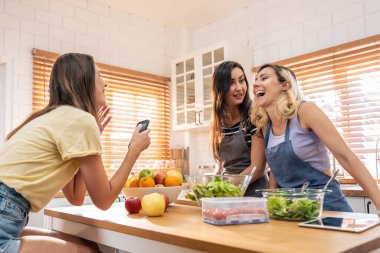 Kafkasyalı genç lezbiyen arkadaş evde mutfakta birlikte vakit geçiriyor. Çekici romantik kız mutlu ve rahat hissediyor, kahvaltıda yemek pişirmekten ve mutluluktan zevk alıyor. Homoseksüel-LGBTQ kavramı.