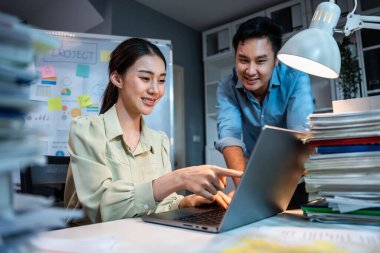 Asyalı borsacı, yatırım borsası ve ofis grafiği hakkında tavsiyede bulunuyor. Çekici iş adamları dizüstü bilgisayar kullanır ve iş yerinde para planı yönetimi ve analizi birlikte yaparlar.