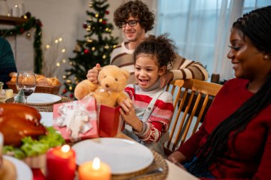 Çok ırklı bir aile Noel partisinde kızına hediye paketi veriyor. Çekici küçük kız yemek yerken akrabasından hediye alıyor. Şükran Günü 'nü evdeki yemek masasında kutluyor.