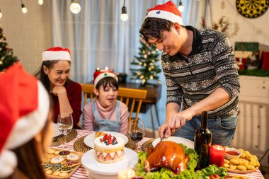 Asyalı sevimli aile Noel partisini evde kutluyor. Çekici ebeveynler ve akrabalar Şükran Günü 'nü kutlamak için yemek yiyorlar. Noel arifesi evde yemek masasında..