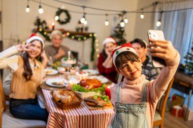 Asyalı bir aile Noel partisini kutlarken fotoğraf çekiyor. Çekici genç kız ve akrabaları yemek yerken Şükran Günü 'nün, Noel arifesinin ve yemek masasının tadını çıkarıyorlar..