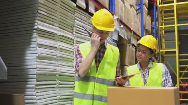 Depoda sarı şapkalı kadın lojistik işçileri.