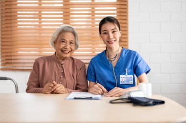 Asyalı güzel bakıcının portresi. Evdeki son sınıf hanımına iyi bak. Çekici uzman bakıcı kadınlar huzurevinde yaşlı ve olgun büyükbabalarına destek oluyor ve kameraya bakıp gülümsüyorlar..