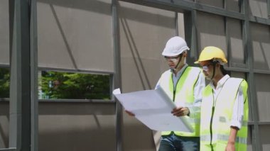 Asyalı işçiler, covid salgın krizi nedeniyle mimari alanında koruyucu yüz maskesi takıyorlar..