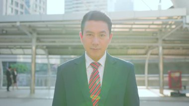 Yakışıklı Asyalı işadamı sokakta duruyor, iş konsepti.