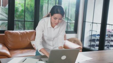 Evde dizüstü bilgisayar kullanan Asyalı bir kadın..