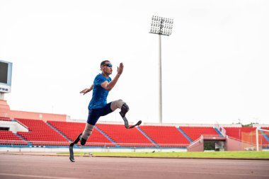 Stadyumda çalışan Asyalı sporcular protez bıçaklarla etkisiz hale getirildi. Çekici ampüte erkek koşucu egzersizi ve fiziksel sınırlamalardan bağımsız olarak Engelli Olimpiyatları antrenmanı.