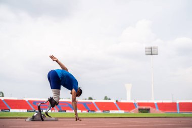 Stadyumda çalışan Asyalı sporcular protez bıçaklarla etkisiz hale getirildi. Çekici ampüte erkek koşucu egzersizi ve fiziksel sınırlamalardan bağımsız olarak Engelli Olimpiyatları antrenmanı.
