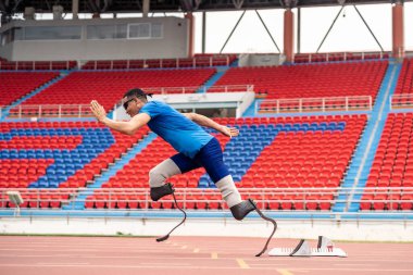 Stadyumda çalışan Asyalı sporcular protez bıçaklarla etkisiz hale getirildi. Çekici ampüte erkek koşucu egzersizi ve fiziksel sınırlamalardan bağımsız olarak Engelli Olimpiyatları antrenmanı.