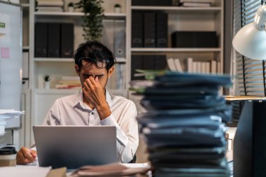 Ofiste masa başında çalışırken Asyalı işadamı gözünü yaraladı. Yoğun çalışan işçiler, geç saatlere kadar çalışmaktan yorgun ve başları ağrıyor. Şirket işyerindeki bilgisayar masasında fazla mesai belgeleri var..