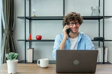 Kafkasyalı genç işadamı evden çalışırken telefonla konuşuyor. Çekici, yakışıklı, serbest çalışan bir adam. Masada oturuyor ve akıllı telefonla konuşuyor. Oturma odasında iş arkadaşıyla iletişim kurmak için.