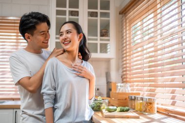 Asyalı romantik adam mutfakta kolyesiyle sürpriz sevgili yapıyor. Çekici, romantik, yeni evli çift erkek ve kadın birlikte vakit geçiriyorlar. Yıldönümünü ve sevgililer gününü evde kutluyorlar..