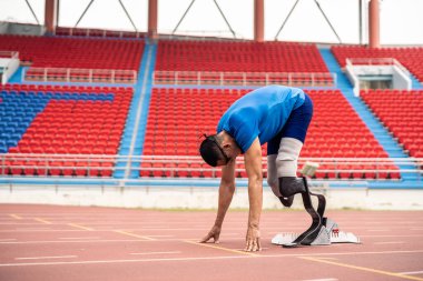 Stadyumda çalışan Asyalı sporcular protez bıçaklarla etkisiz hale getirildi. Çekici ampüte erkek koşucu egzersizi ve fiziksel sınırlamalardan bağımsız olarak Engelli Olimpiyatları antrenmanı.
