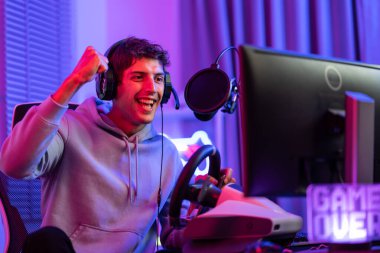 Kafkasyalı genç Esport erkek oyuncu bilgisayarda online video oyunu oynuyor. Yakışıklı oyuncu mutlu ve heyecanlı hissediyor, evde siber turnuva oynarken canlı yayında teknolojinin tadını çıkarıyor..