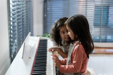 İki Asyalı sevimli kardeş evdeki oturma odasında piyano çalıyorlar. Mutlu Aile, küçük kız çocukları mutlu ve rahat hissederken boş zamanlarını evdeki müzik sınıfında öğrenerek geçiriyorlar..