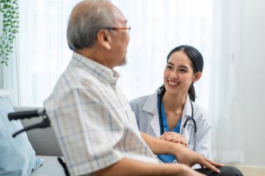 Asyalı genç bakıcı, tekerlekli sandalyedeki yaşlı adama dikkat et. Çekici hemşire doktor yaşlı olgun erkek hastalara bakım evinde fizik tedavi uygulayarak destek oluyor. Sağlık sigortası.