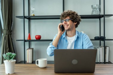 Kafkasyalı genç işadamı evden çalışırken telefonla konuşuyor. Çekici, yakışıklı, serbest çalışan bir adam. Masada oturuyor ve akıllı telefonla konuşuyor. Oturma odasında iş arkadaşıyla iletişim kurmak için.