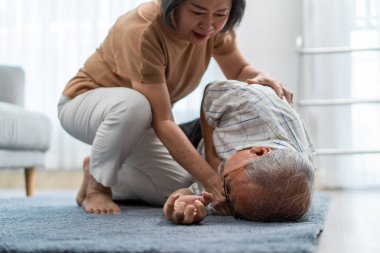 Asyalı kıdemli eş yaşlı kocanın yere düşmesini önlüyor. Çekici yaşlı bir adam kalp krizinden göğüs ağrısı çektikten sonra kaza geçirip oturma odasında olgun bir kadın tarafından kurtarıldı..