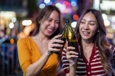 Asyalı kadın arkadaşlar ellerinde bira şişesi, barın önünde parti veriyorlar. İki güzel bayan gezgin şehir dışına seyahat ediyor, gece kulübünde tatil gezisinde kutlama yaparak vakit geçiriyorlar..