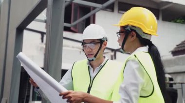 Asyalı işçiler, covid salgın krizi nedeniyle mimari alanında koruyucu yüz maskesi takıyorlar..