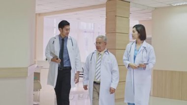 Bir grup doktor ve tıbbi personel hastane koridorunda yürüyor.