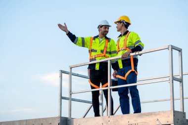 Açık hava deposunda çalışan çeşitli erkek teknisyenler. Yenilik mühendisi güvenlik donanımı giyen adamlar depo fabrikasının dışında çevresel yenilenebilir temiz enerji geliştirmek için çalışıyorlar..