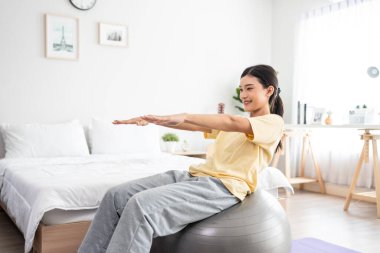 Asyalı genç ve güzel sporcu kadın evde yoga pilates yapıyor. Çekici kız egzersizi, egzersiz pozu nefes alma ve evde sağlık yaşam tarzı ve diyet için yoga ile meditasyon..