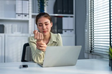 Bir iş kadını masaj eli ofiste eklem ağrısından muzdarip olur. Çekici kadın çalışanlar bileklerine dokunur ve iş yerinde aşırı çalışırlarken uyuşukluktan avuç içlerine eklem germeye çalışır.